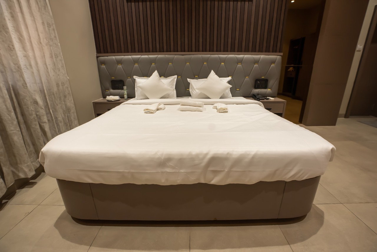 Double bed with a padded headboard and bedside lighting