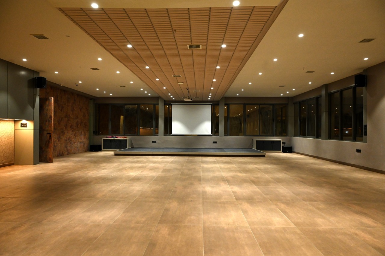 Illuminated function hall with an open floor and raised stage